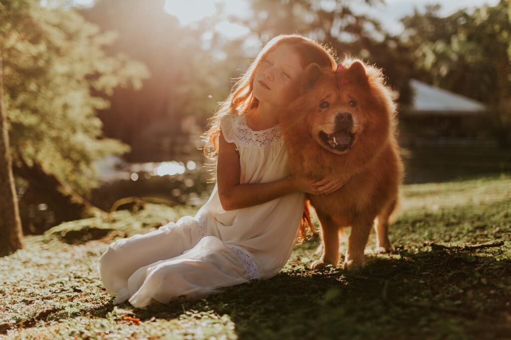 maedchen-kuschelt-mit-hund-iin-der-sonne-im-gartenjpg